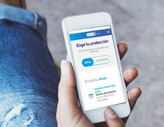 Persona con los pies encima de una maleta y en su móvil la protección de un seguro de Zurich