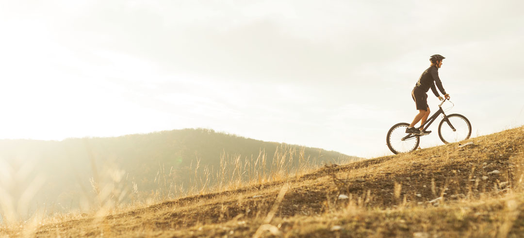 Hombre subiendo una montaña en bicicleta